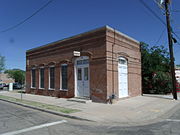 The John Nicolas Saloon was built in 1889 and is located in 46 E. 11th St. Designed by prominent Arizona architect James M. Creighton, this is the oldest standing fired-brick building in Florence. French-born rancher farmer John Nicholas moved his saloon to this building soon after its construction in 1889. Listed as Historic by the Historic District Advisory Commission.