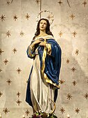 A bronze life-sized polychromed statue of the Immaculate Conception located above the high altar.