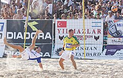 Photograph of two men in a beach soccer pitch