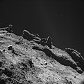 菲莱登陆器在距离大约彗星表面10公里处所拍摄的彗星67P的照片，2014年11月9日。此图片显示一个857x857米的区域。可以想像到，表面上的小石头实际上跟住宅大楼一样大。[20]