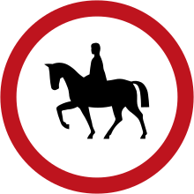 Round road sign circled in red with a rider in the middle