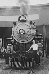 Railroad photographer Roger Puta standing on the pilot steps of No. 5629 at an N&W roundhouse in Indianapolis, on May 21, 1966