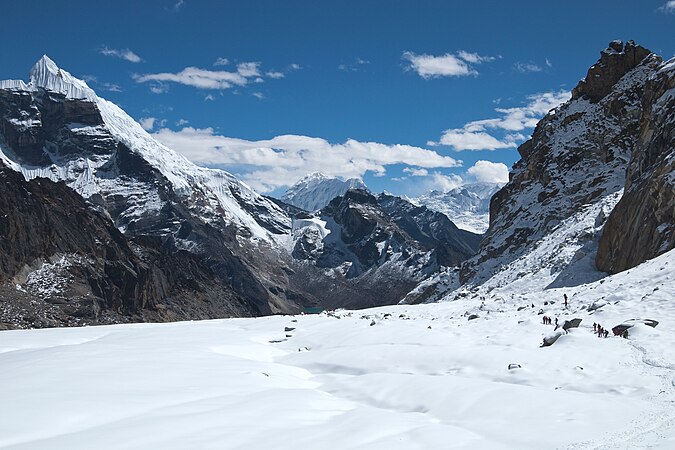 图为从海拔5400米的乔拉山道往东看的景观。乔拉山道位于喜马拉雅山脉的尼泊尔珠穆朗玛区，在大喜马拉雅山脉的南边。山道上景色众多，有被雪覆盖的冰原、露出地层的黑色悬崖，前面的山谷还有个小冰湖。