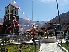 An image of Callahuanca Main Sqaure as seen in 2021 with festive flags and a roundabout