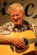 Doc Watson playing an acoustic guitar.