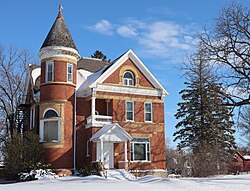 Two-and-a-half story brick house with a three-story corner tower