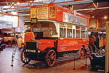 A red 1920s open top double decker bus