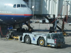 A conventional tractor hooked up to a United Airlines Boeing 777-200ER at Denver International Airport