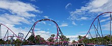 A train twisting through DC Rivals HyperCoaster's non-inverting loop, seen from the car park