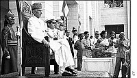 Muhammad Ali Jinnah, founder of Pakistan, is sitting on the Chair of Governor General, sometimes referred as Pakistan's Throne, wearing Sherwani.
