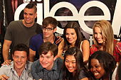Eight people are looking towards the camera and smiling