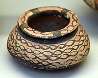 Jar. The surface is painted with lustrous black paint on a salmon-pink slip. Halaf period, 6000-5000 BC
