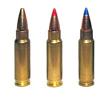 Photo of three 5.7×28mm cartridges as used in the Five-seven pistol. The left cartridge has a plain hollow tip, the center cartridge has a red plastic V-max tip, and the right cartridge has a blue plastic V-max tip.