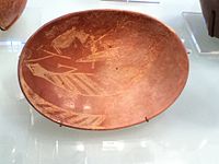 A plate created during the Early Dynastic period of Ancient Egypt. It depicts a man on a boat alongside a hippopotamus and a crocodile