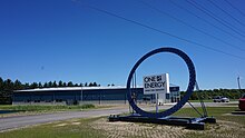 One Energy Wind for Industry" outside blue office building with wind turbine in background