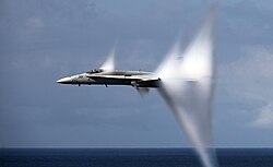 Complex set of condensation cones surrounds a F/A-18C at transonic speed