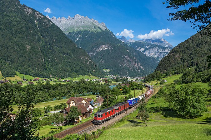 图为一列在瑞士厄尔斯费尔德（背景中可见）附近的哥逹线上南行的多式联运货运列车，型号为Re 4/4 II和Re 6/6。