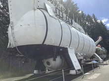 A white-colored submarine with black painted bands.