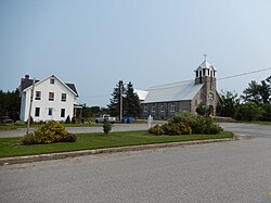 Photo of a street with a house and a church.