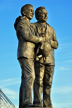 statue of two men hugging in suits