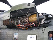 side view of a helicopter with the engine bay open, displaying engine internals