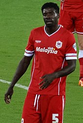 A footballer wearing an all red kit.