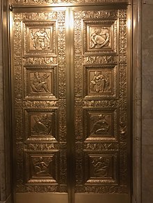 A double-leaf elevator door in the lobby, with gilded carvings