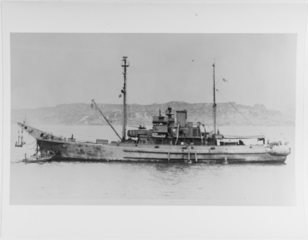 USS Cliffrose (AN-42) In a harbor, c. 1945. She appears to be lifting a large anchor