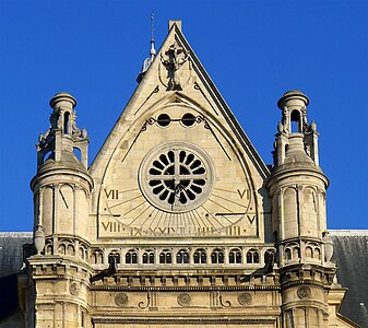 Detail of the south transept and sundial, with sculpture of deer with crucifix at top