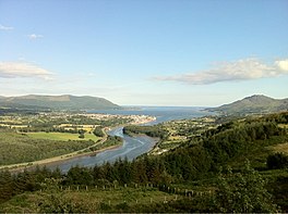 Image of Carlingford Lough in the distance with the Newry River in the foreground. The town of Warrenpoint sits in the center of the image.
