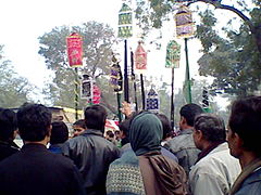 Muharram procession in India carrying alams that symbolize the ensign of Husayn