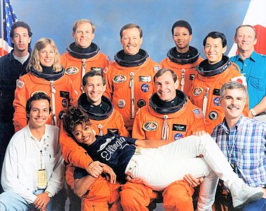Alternate crew and support staff photo, featuring the seven crewmembers and spacesuit technician Sharon McDougle, front center, among others.