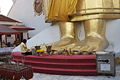 A woman prays at Buddha's feet