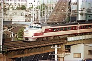 Diesel train going over a rail bridge in urban area