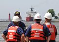 Coast Guardsmen await the arrival of the USCGC Mackinaw