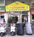 一家由泰国人在香港经营的泰国菜馆，门口的招牌上的店名有泰文、中文和英文对照。