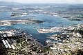 Aerial photograph of the Pearl Harbor Naval Base showing naval shore facilities in the foreground and Ford Island in the center.