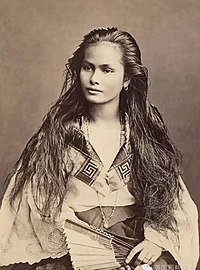 A seated Filipino mestiza woman with long hair holding a fan