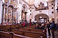 Pilgrims inside the church looking to the altar of the Infant Jesus of Prague