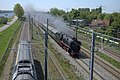 Steam train overtaking an electric train