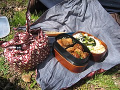 Two typical homemade bento (one open, one wrapped) with furoshiki cloths.