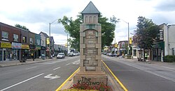 Stone marker in the middle of a road, marked 'The Kingsway'