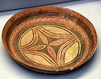 Shallow plate. The interior is decorated with a floral design in the center, with polychrome in black and red on the buff surfaces. 6000-5000 BC