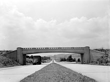 Four-lane highway with overpass, photographed from median