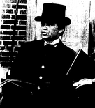 Black and white photo of a man in a top hat and overcoat