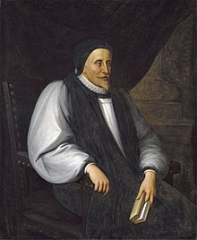 A solemn old white man clothed in Reformation-era clerical robes, seated and holding a book