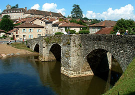 The Romanesque bridge in Solignac, with the abbey and surrounding buildings beyond