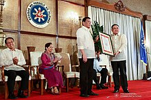 Rodrigo Duterte is given a framed document showing the results of the Bangsamoro plebiscite as part of a ceremony