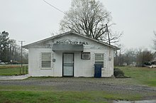 White cinderblock and wood building displaying the letters "RONDO CITY HALL".