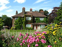 View of modest-sized country house from extensive gardens